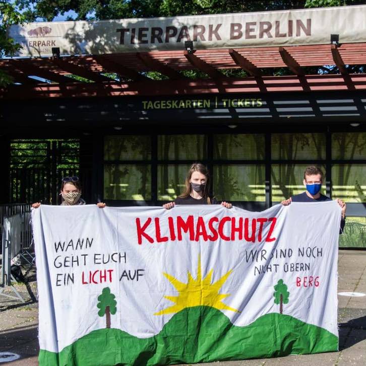 Kinder halten ein selbstemaltes Leintuch zum klimaschutz